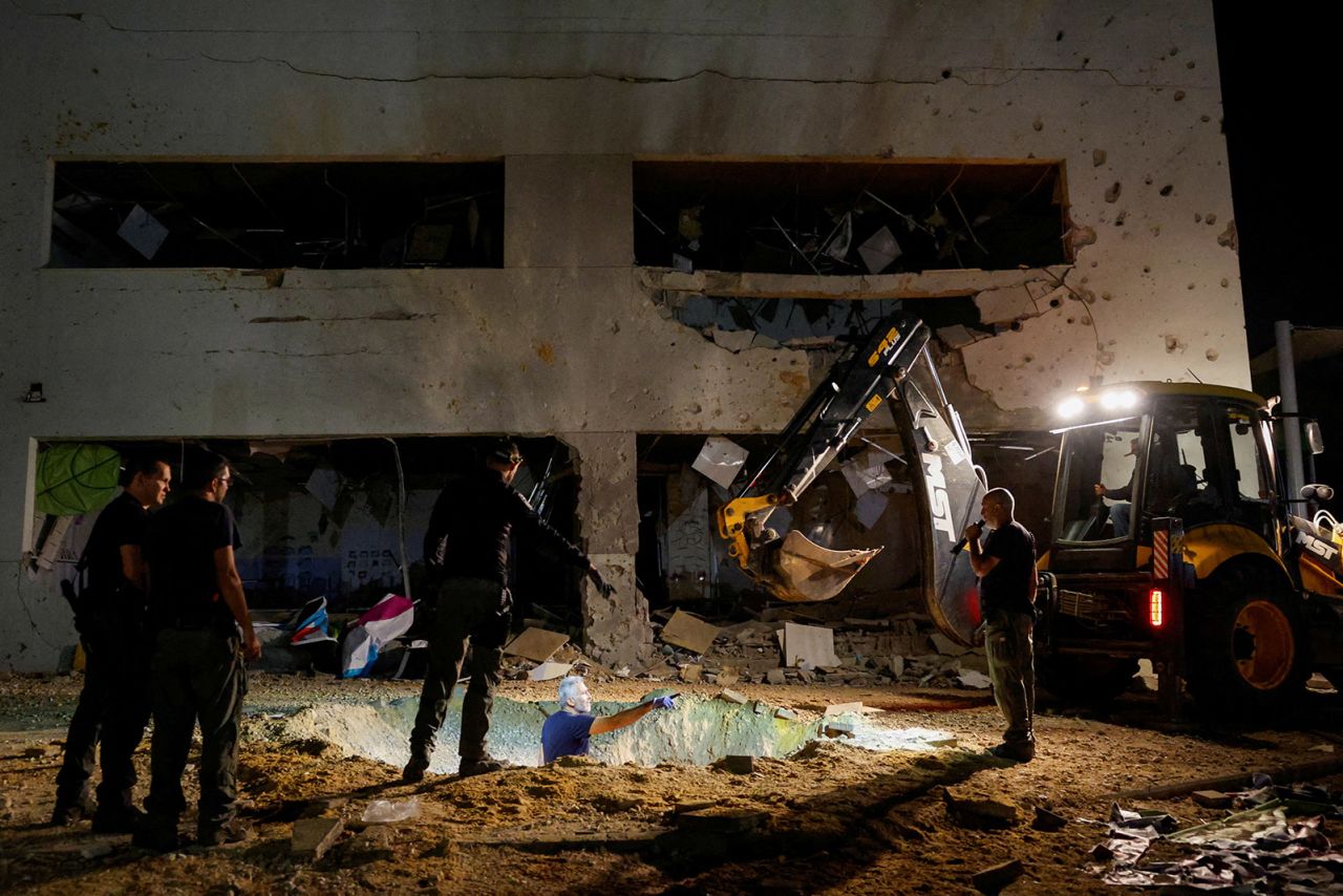 Israeli rescue force members inspect the site where a missile fired from Iran towards Israel hit a school building, in central Israel, on October 1, 2024.