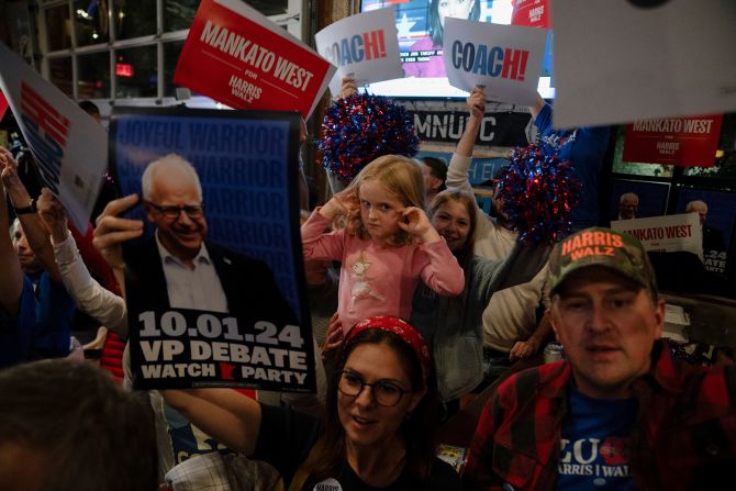 Margaret Jagdfeld, 4, covers her ears as alumni of Mankato West High School, where Walz formerly taught, cheer at a watch party event in St. Paul, Minnesota.