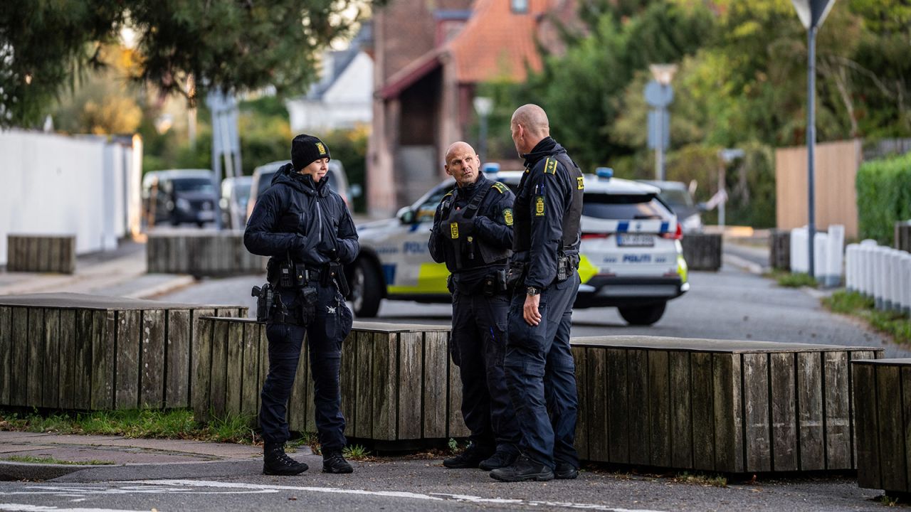 Police officers talk during the investigation of blasts near the Israeli embassy in Copenhagen, Denmark, on October 2, 2024.