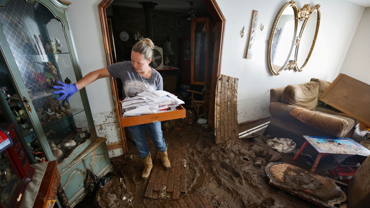 Sabra English carries important papers out of her father's flooded home in Barnardsville, North Carolina.