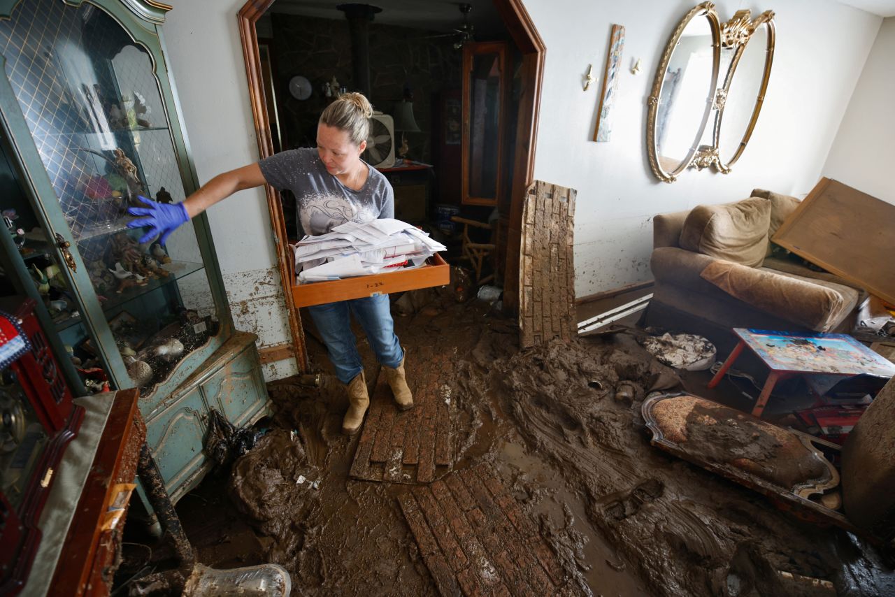 Sabra English carries important papers out of her father's flooded home in Barnardsville, North Carolina.