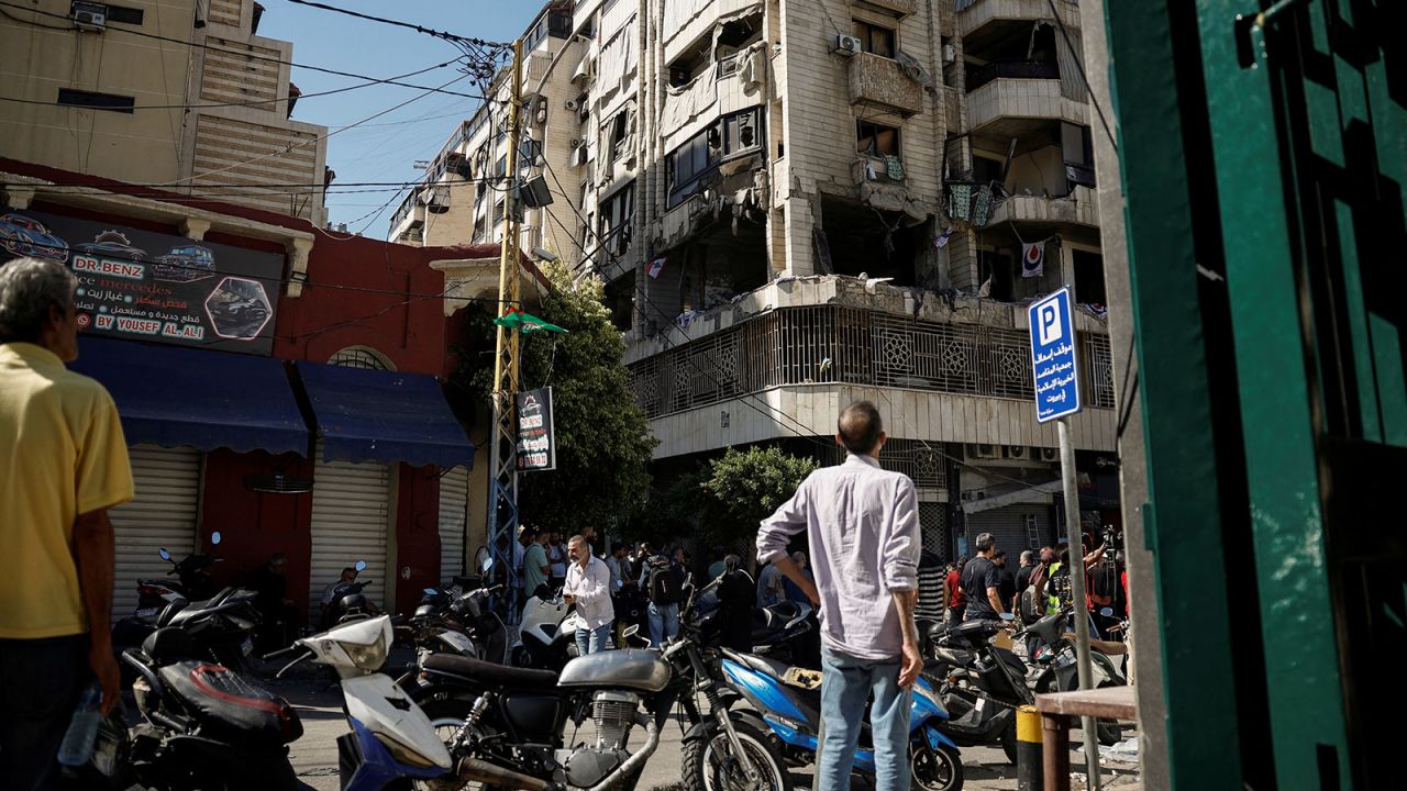 People look at a damaged building at the site of an Israeli strike on central Beirut's Bachoura neighborhood on October 3.