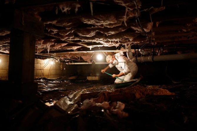 A man helps clean out a home's flooded crawlspace in Cruso, North Carolina, on Thursday.