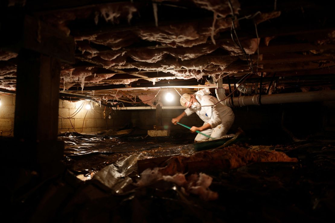 A volunteer helps clean up a flooded crawlspace beneath a home affected by Hurricane Helene in Cruso, North Carolina, on Thursday.