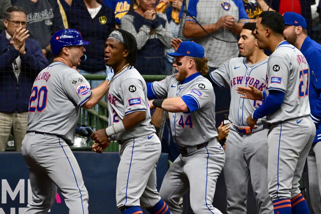 Mets players celebrate with Alonso (left) after his home run.