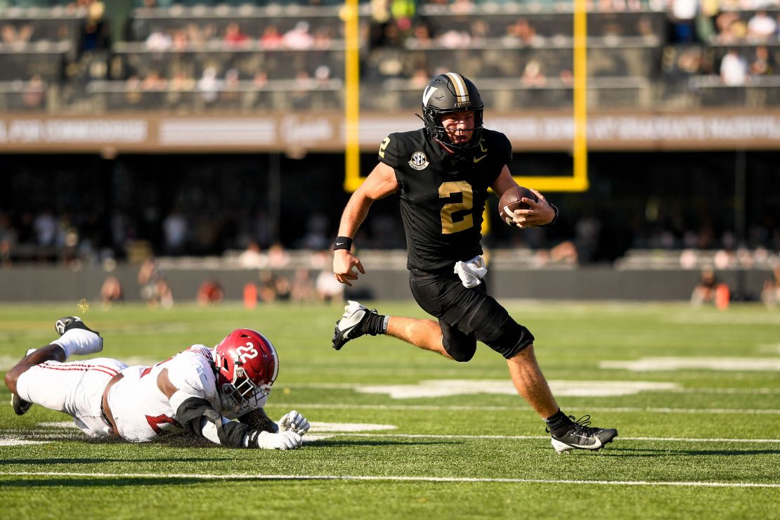 Vanderbilt Commodores quarterback Diego Pavia (2) breaks through the tackle of Alabama Crimson Tide defensive player LT Overton (22).