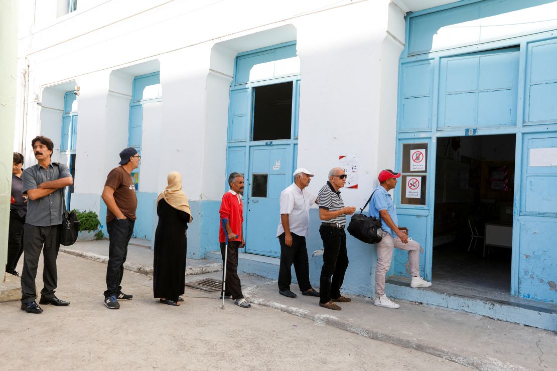 People stand in line outside a polling station during the presidential election in the capital Tunis, Tunisia, on October 6, 2024.