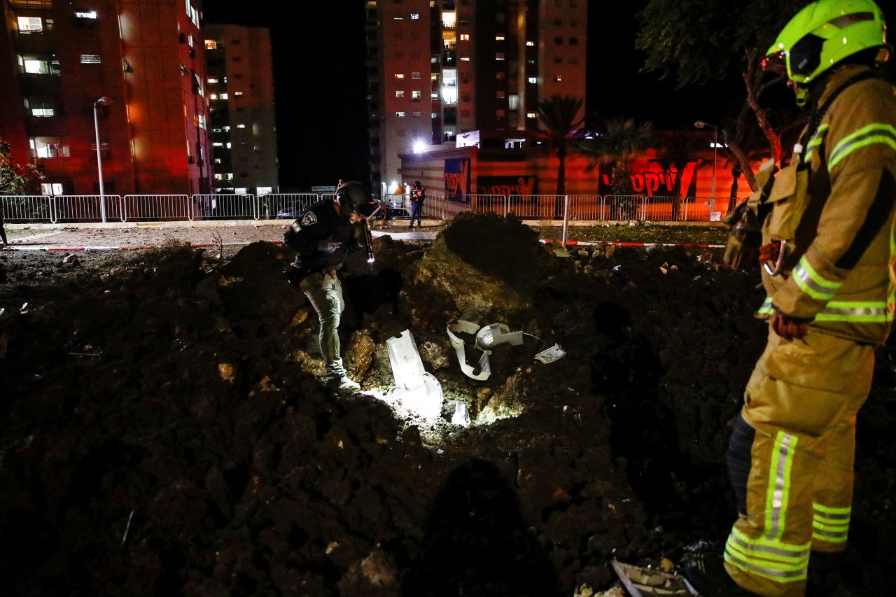 Israeli rescue force members inspect the site where a projectile fell in Haifa, northern Israel, on Sunday.