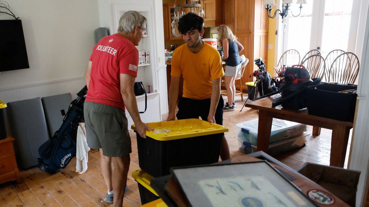 Rich Lorenzen and his son Sam Grande carry their belongings as they prepare to evacuate their home before the arrival of Hurricane Milton, in St. Pete Beach, Florida, on Monday.