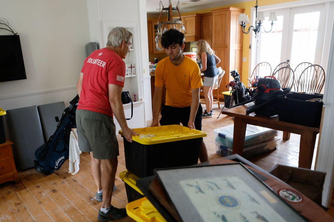 Rich Lorenzen and his son Sam Grande carry their belongings as they prepare to evacuate their home ahead of the arrival of Hurricane Milton, St. Pete Beach, Florida, on October 7.