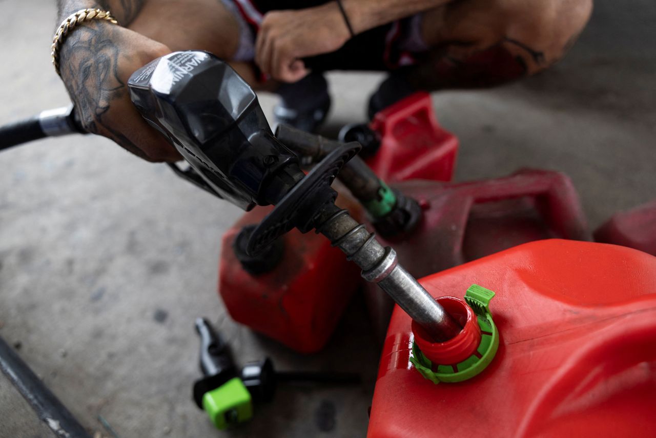 A man fills up gas containers in Tampa, Florida, on October 8.