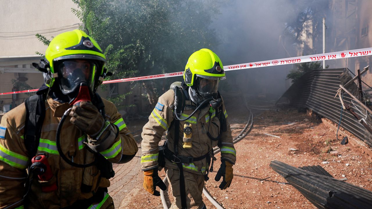 Firefighters work as they put out a fire at a residential building in Kiryat Shmona, Israel, on October 9.