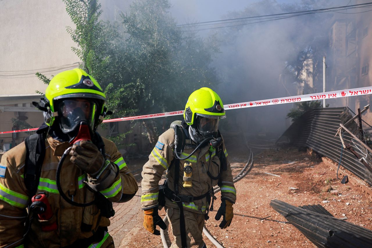 Firefighters work as they put out a fire at a residential building in Kiryat Shmona, Israel, on October 9.