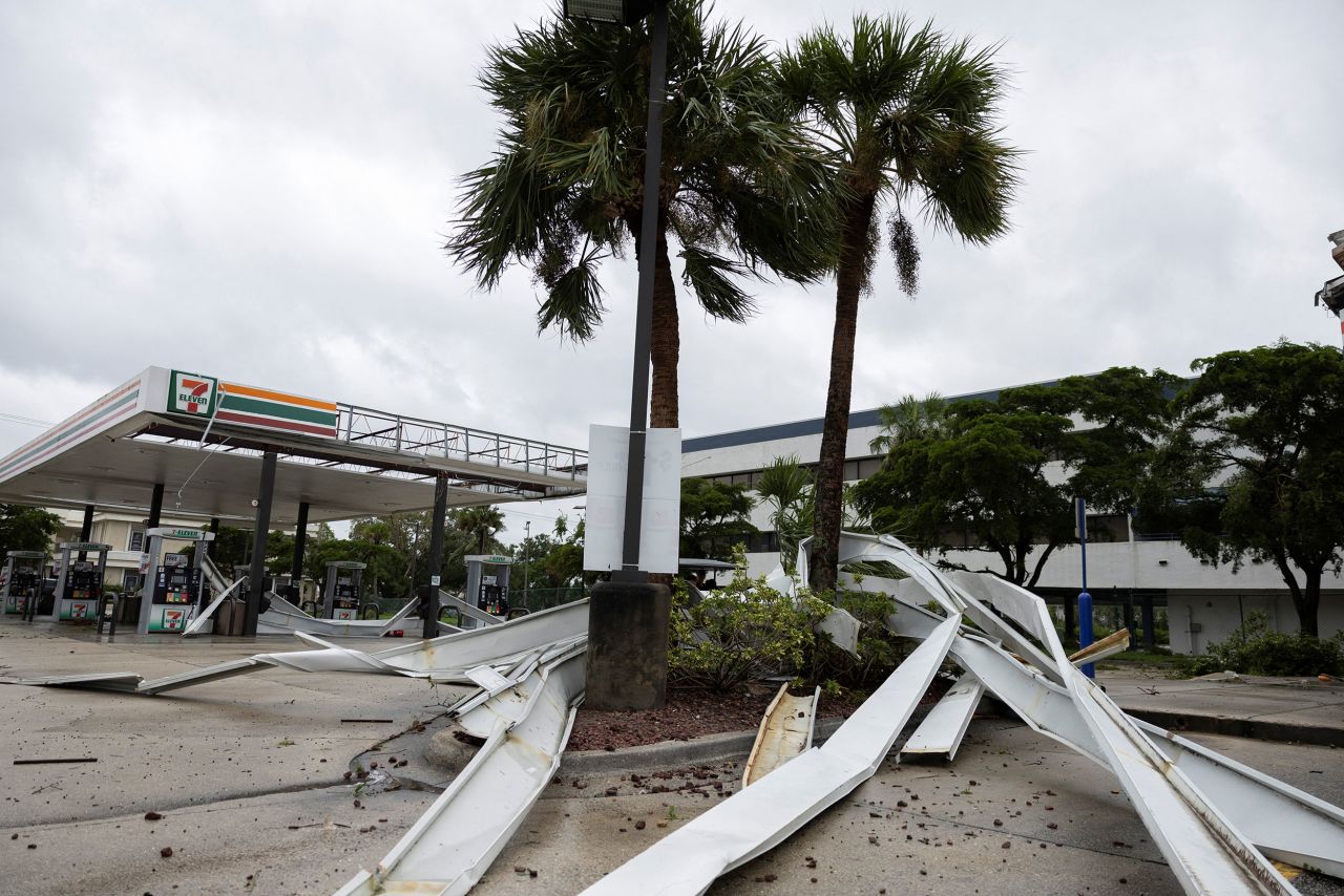 Parts of the roof of a gas station lie around palm trees on Wednesday in Fort Myers.