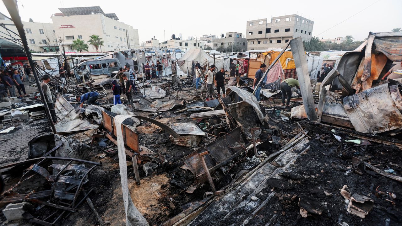 Palestinians inspect the damage at the site of an Israeli strike on tents sheltering displaced people at Al-Aqsa Martyrs hospital in Deir Al-Balah, Gaza, on October 14.