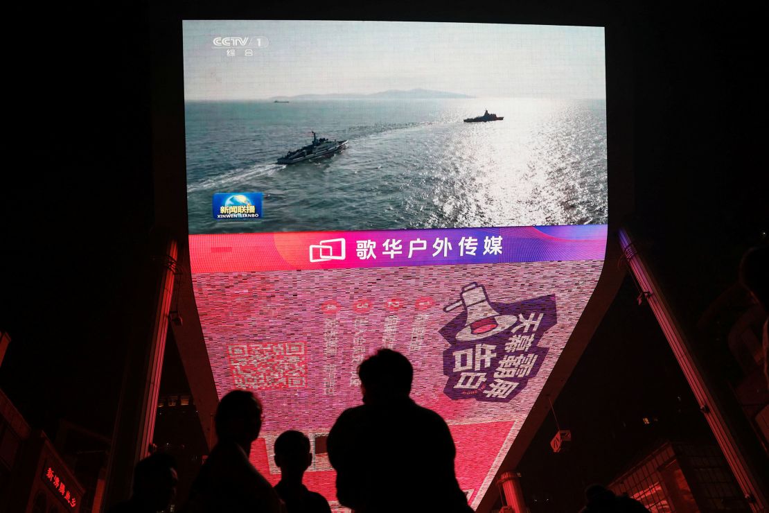 Een scherm in Beijing toont nieuwsbeelden van militaire oefeningen onder leiding van het Chinese Volk Bevrijdingsleger rond Taiwan op 14 oktober 2024.