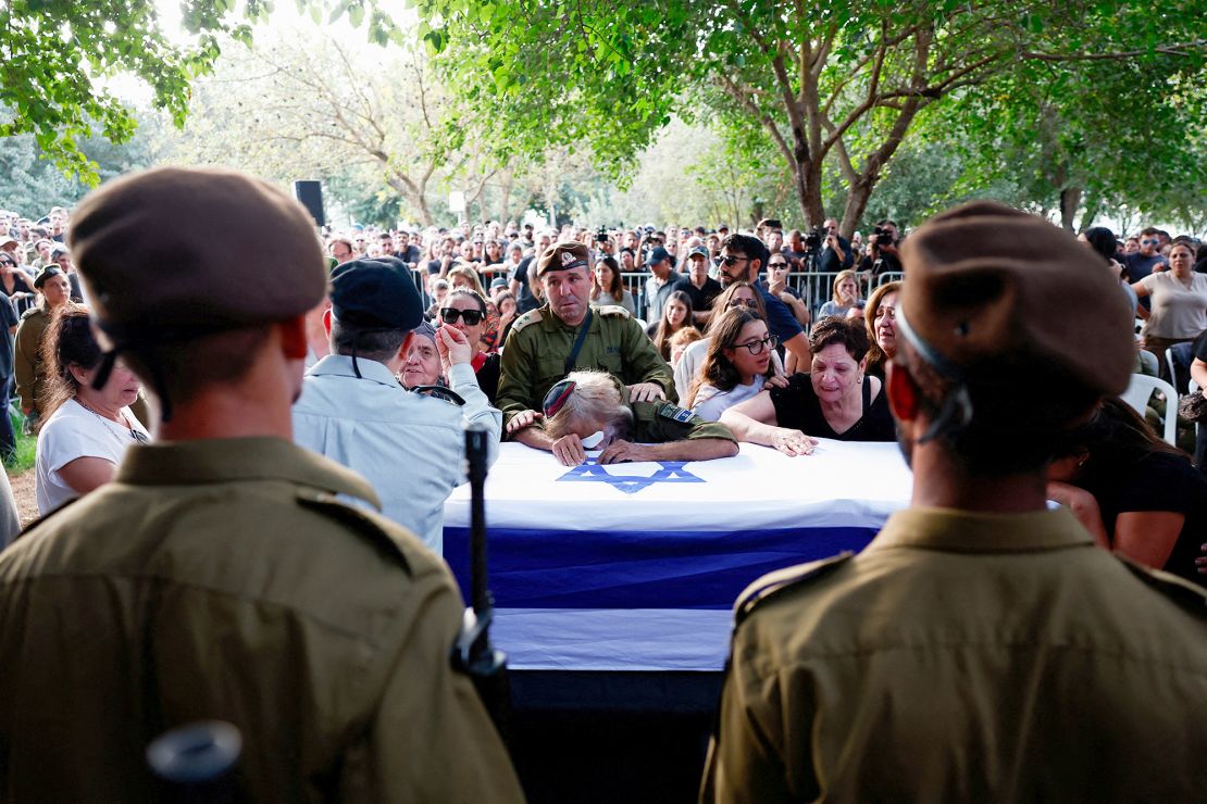 La gente llora la muerte del soldado israelí sargento Amitai Alon, que murió en el ataque con drones el domingo. (Gonzalo Fuentes/Reuters)