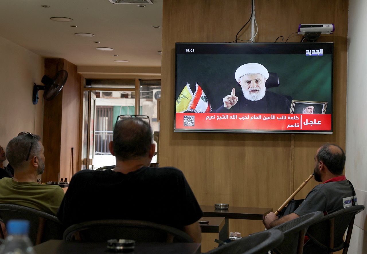 People watch Hezbollah deputy leader Naim Qassem delivering a televised address as they sit in a cafe in Beirut, Lebanon, on October 15.