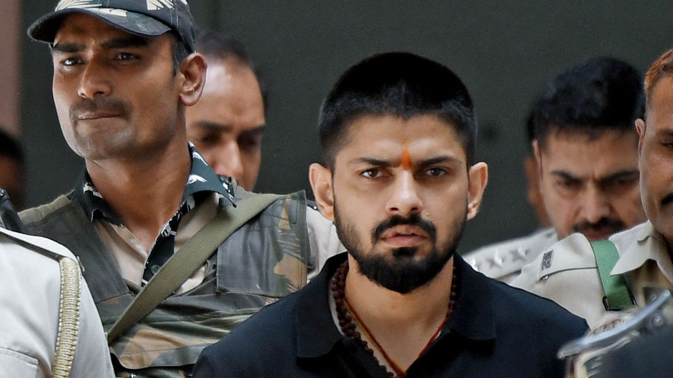 Policemen escort Lawrence Bishnoi (center) into a court, in New Delhi, India on April 18, 2023.