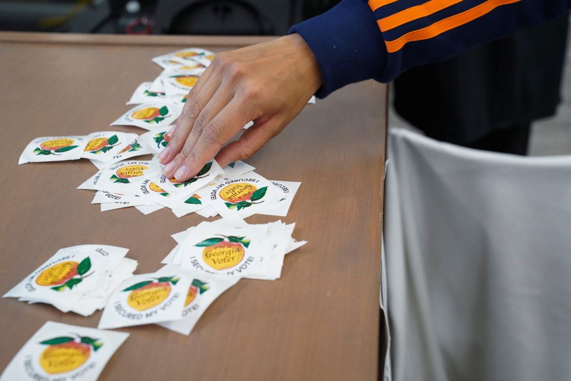 A person picks up a sticker at a polling place in Atlanta on October 16, 2024.