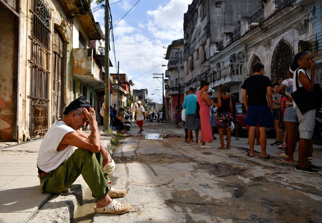 A man sits on a sidewalk in the Cuban capital, Havana, as the island suffered power problems in October.