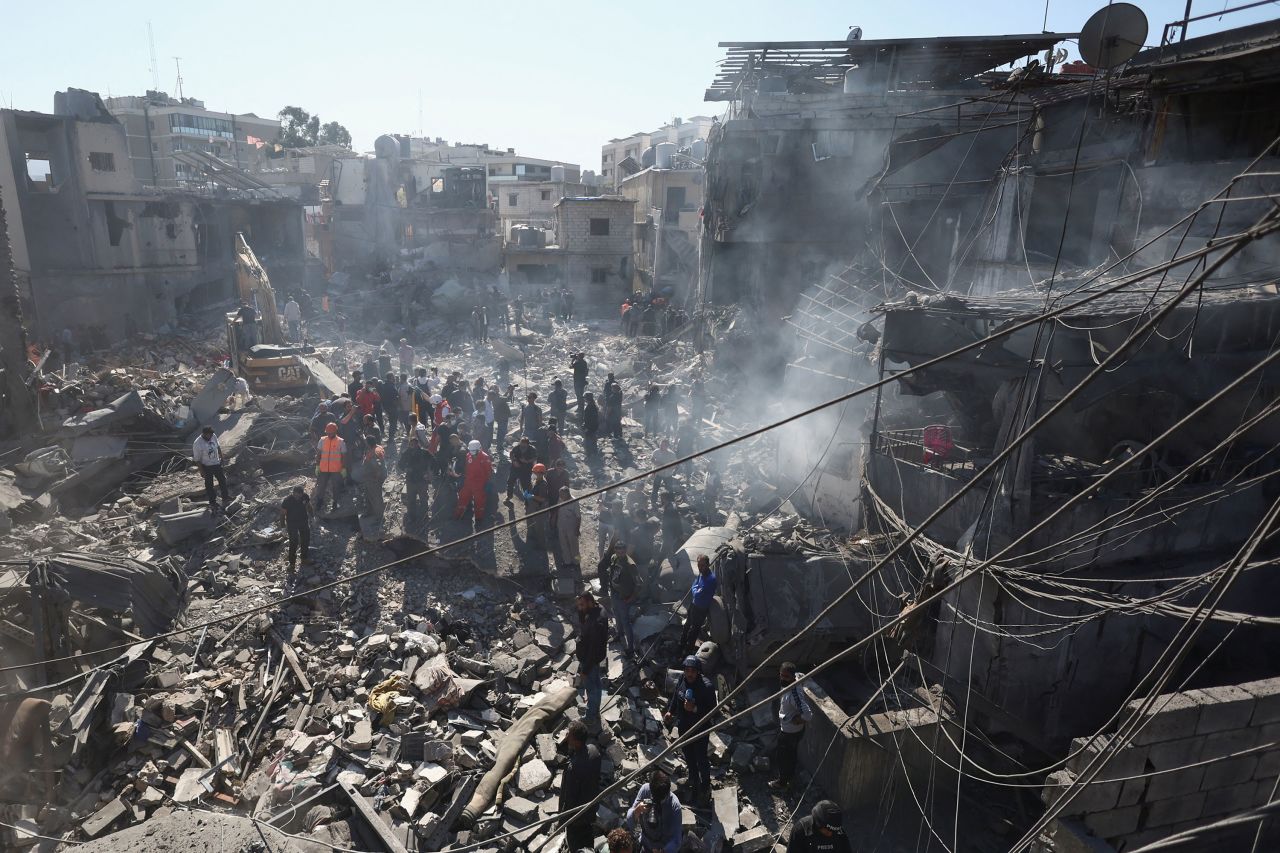 People inspect damage at the site of the strike near Rafik Hariri University Hospital in Beirut on Tuesday.