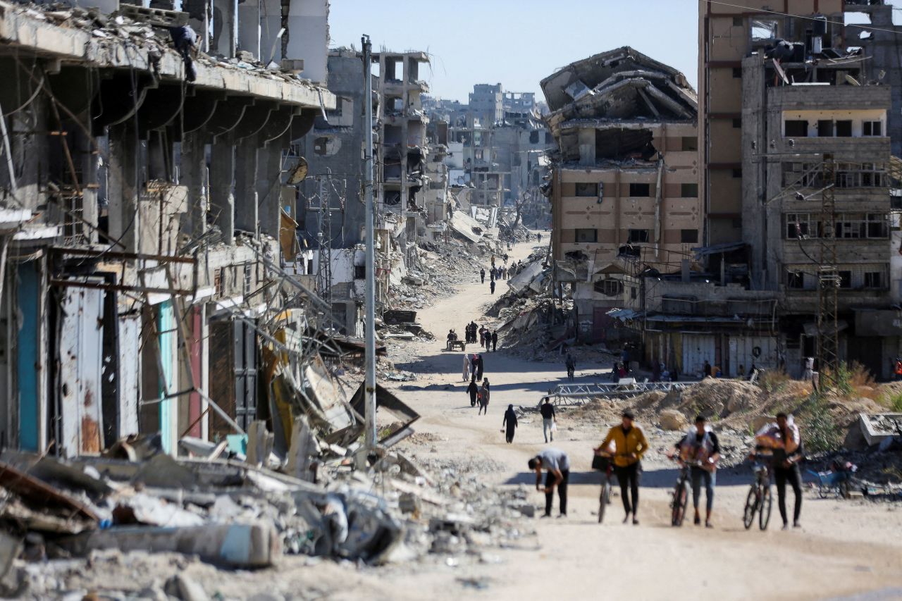 Palestinians walk through a destroyed neighborhood in Gaza City on October 24.