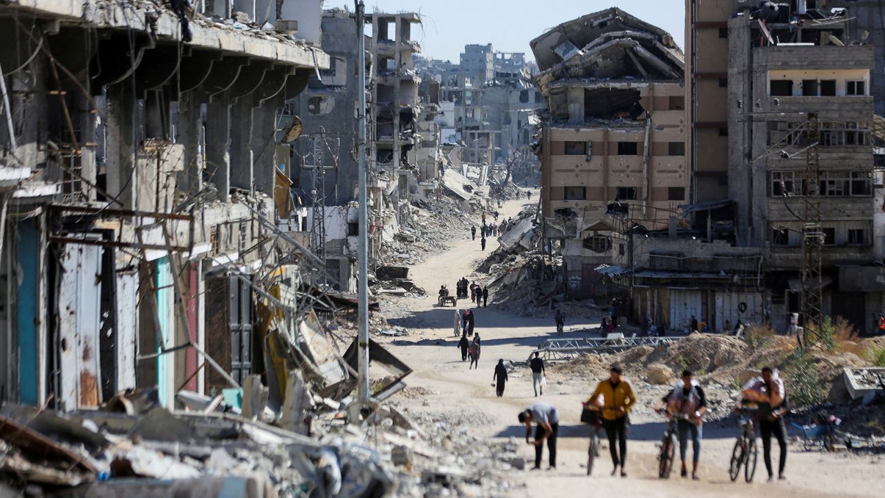 Palestinians make their way in a devastated neighborhood, in Gaza City, on October 24.