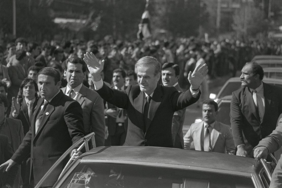 Syria's late President Hafez al-Assad waves from his car to cheering crowds in the streets of Damascus on the occasion of the 16th anniversary of the movement that brought him to power on November 16, 1987.