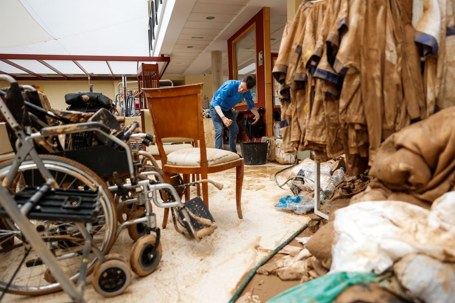 A man cleans mud from inside a home for elderly people in Sedavi on Saturday.