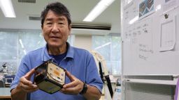 Takao Doi, a former Japanese astronaut and professor at Kyoto University, holds an engineering model of LignoSat during an interview with Reuters at his laboratory at Kyoto University in Kyoto, Japan, October 25, 2024. REUTERS/Irene Wang