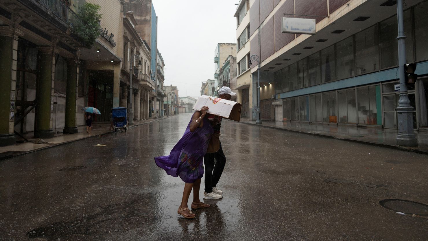 People walk on a street as Hurricane Rafael passes over Havana on Wednesday.