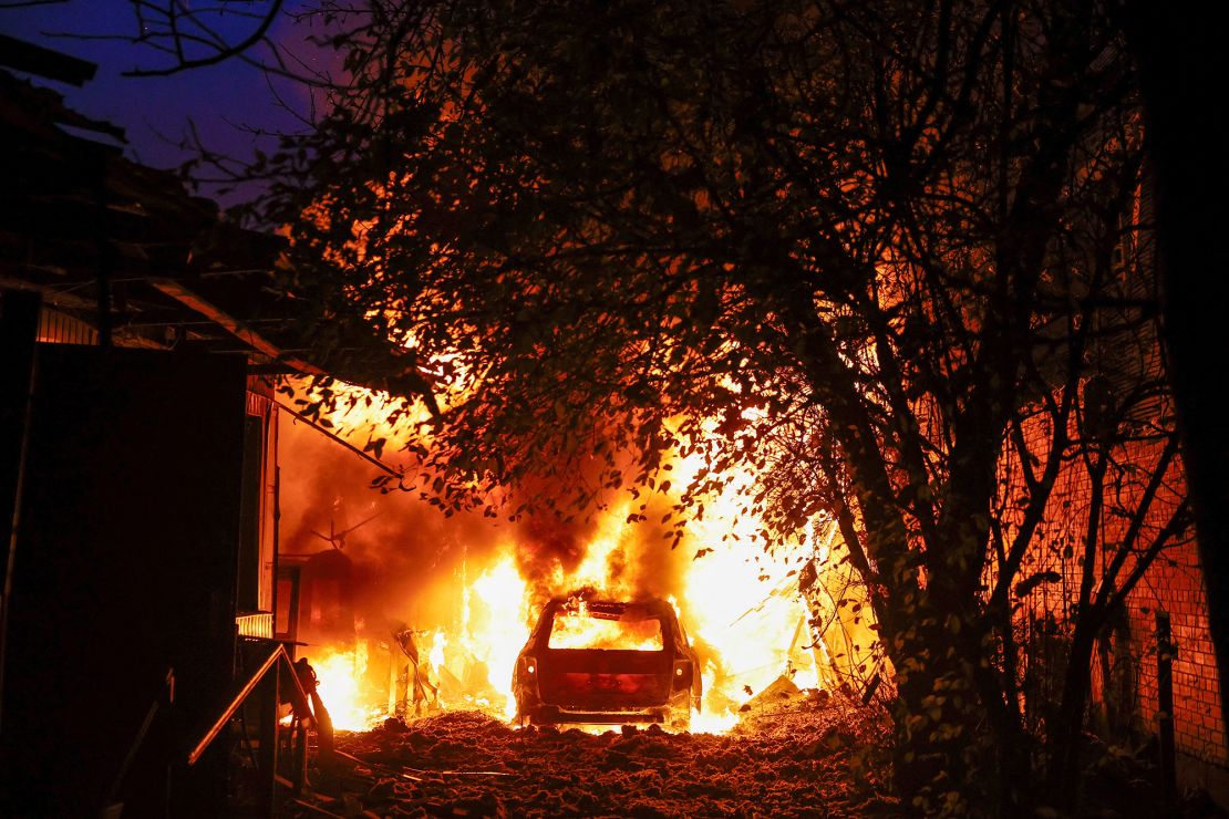 A car and house burn after they were damaged from a Russian drone strike in Kyiv on Thursday.