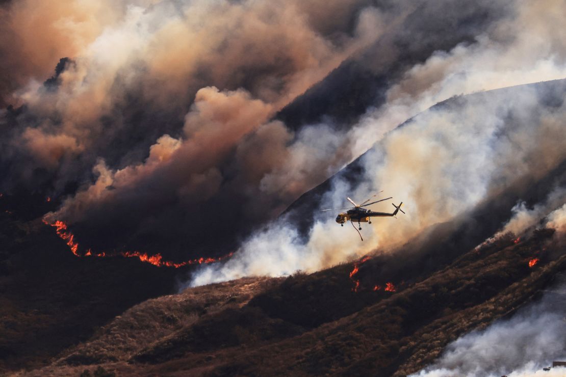 An helicopter flies as smoke billows from the Mountain Fire in Santa Paula, California, U.S., November 7, 2024. REUTERS/David Swanson TPX IMAGES OF THE DAY