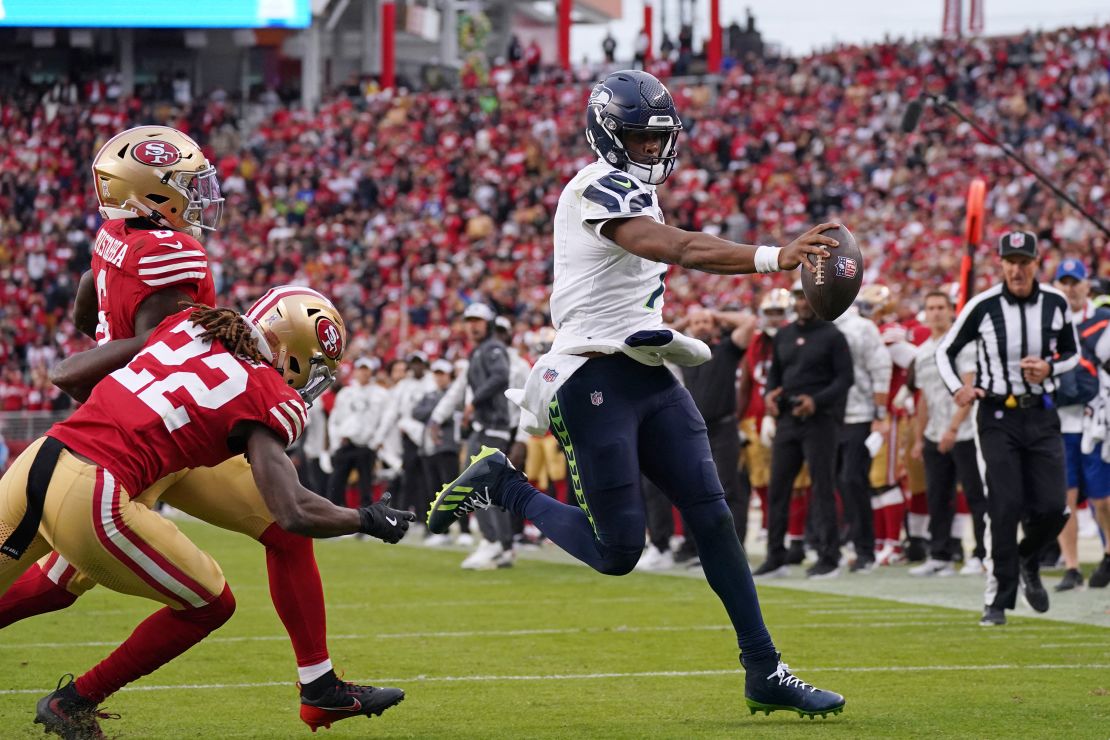 Nov 17, 2024; Santa Clara, California, USA; Seattle Seahawks quarterback Geno Smith (7) scores a rushing touchdown past San Francisco 49ers cornerback Isaac Yiadom (22) to win the game in the fourth quarter at Levi's Stadium. Mandatory Credit: David Gonzales-Imagn Images