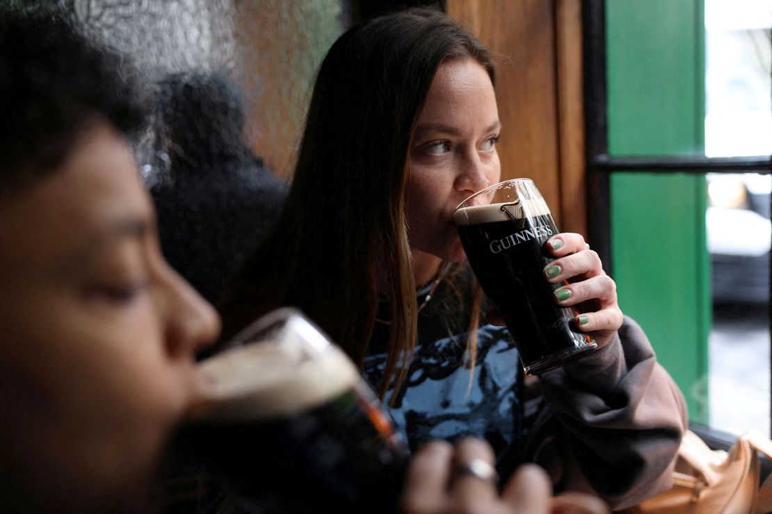 People drink Guinness beer at the Devonshire pub in London on October 10.