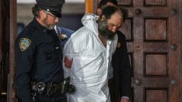 New York City stabbing spree suspect Ramon Rivera is escorted out of the 10th Precinct in New York City on Tuesday.