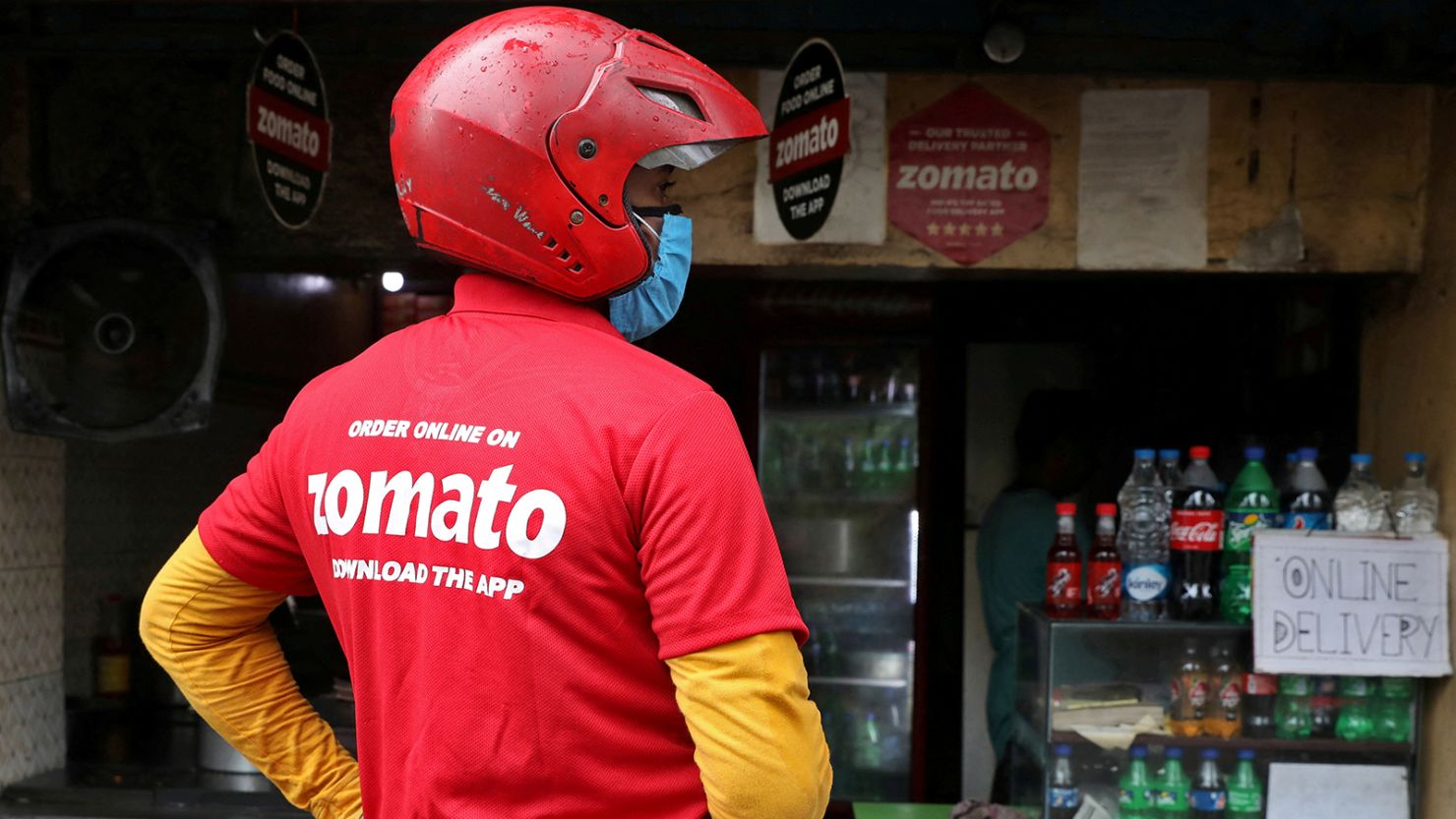 A Zomato delivery driver waits to collect an order outside an eatery in Kolkata, India.