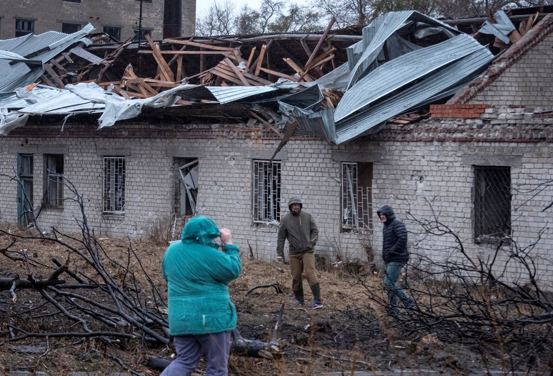 Residents walk at a site of the Russian missile strike in Dnipro, Ukraine on Thursday.