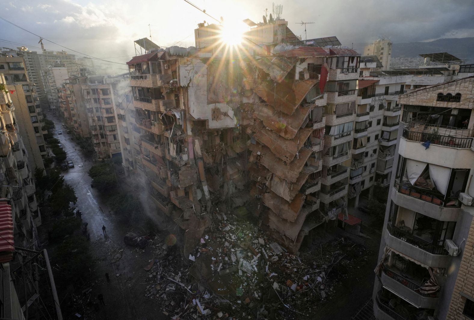 People walk past damaged buildings, in the aftermath of Israeli strikes on Beirut's southern suburbs, amid the ongoing hostilities between Hezbollah and Israeli forces, Lebanon November 25, 2024. REUTERS/Mohammed Yassin TPX IMAGES OF THE DAY