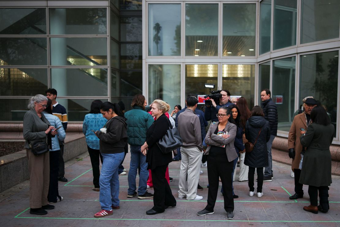 People wait in line to enter the Van Nuys Courthouse West ahead of the status hearing.