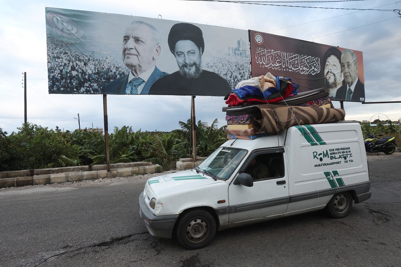 Lübnan'ın Sur kentinde, 27 Kasım'da, Lübnan Meclis Başkanı Nebih Berri ve İmam Musa el-Sadr'ın fotoğrafının önünden geçen bir araç, eşyaları taşıyor.