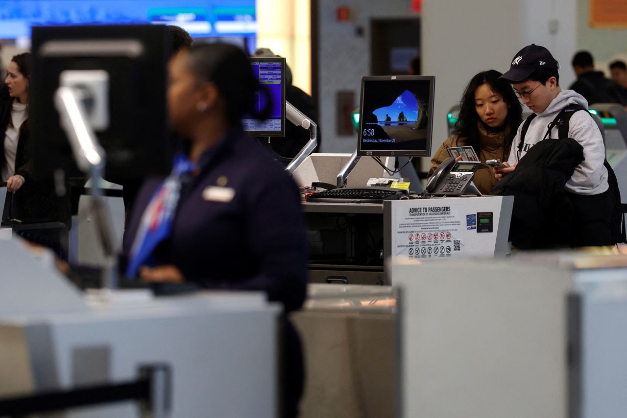 Travelers arrive at LaGuardia airport in New York, on Wednesday.