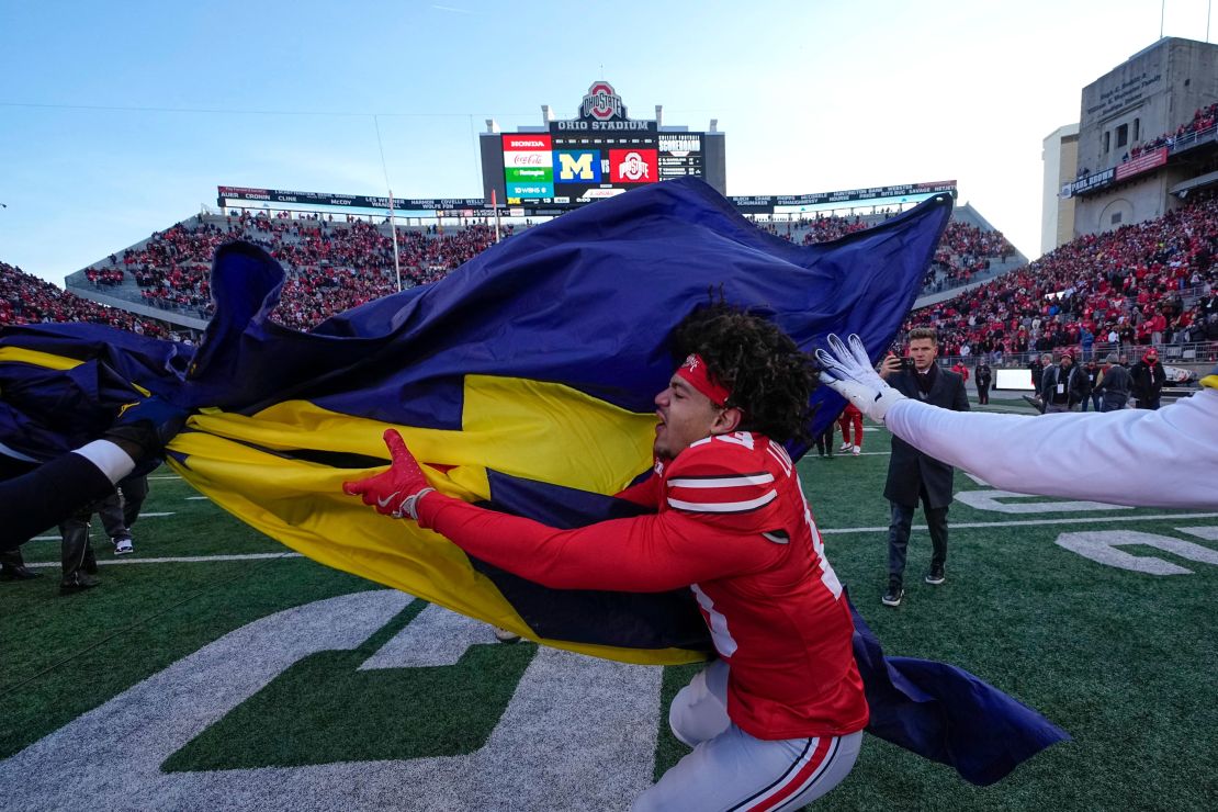 Ohio State cornerback Miles Lockhart tries to grab the Michigan flag as the teams fight on the field.