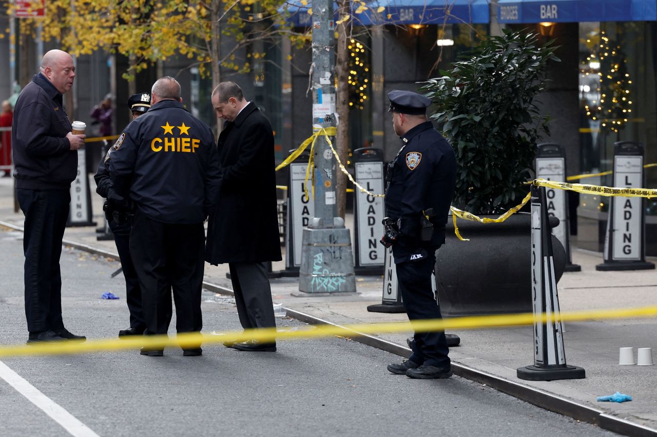 Police officers stand near the scene where the CEO of UnitedHealthcare Brian Thompson was reportedly shot and killed in Midtown Manhattan, New York, on Wednesday.