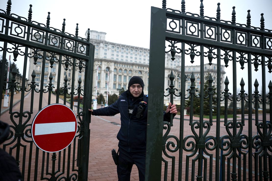 A Jandarmeria member closes a gate to the Palace of Parliament, after the Romanian top court annulled the result of the first round of the presidential election, in Bucharest on Friday.