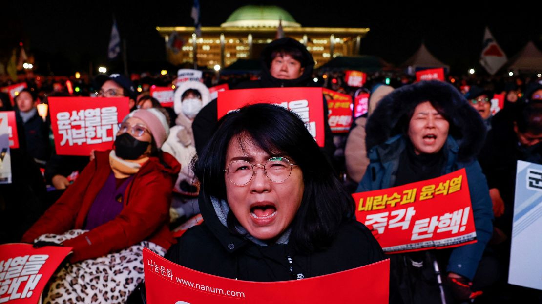 A protester holds a placard during a rally calling for the impeachment of South Korean President Yoon Suk Yeol in front of the National Assembly in Seoul, South Korea on December 7.