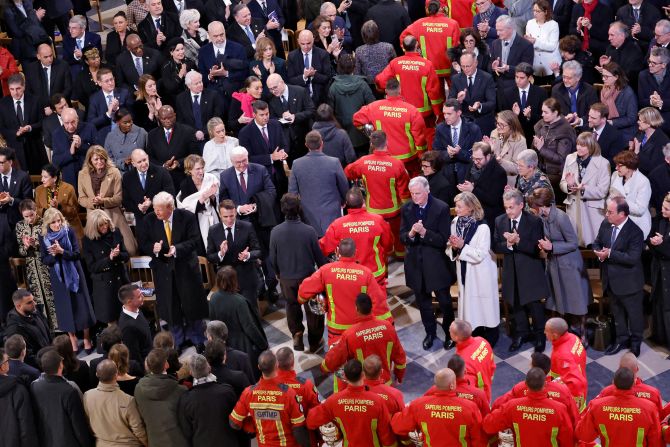 Firefighters, rescuers and builders involved in the restoration walk through the nave past attendees including US President-elect Donald Trump, current US first lady Jill Biden and Britain’s Prince William, as well as other world leaders and dignitaries.