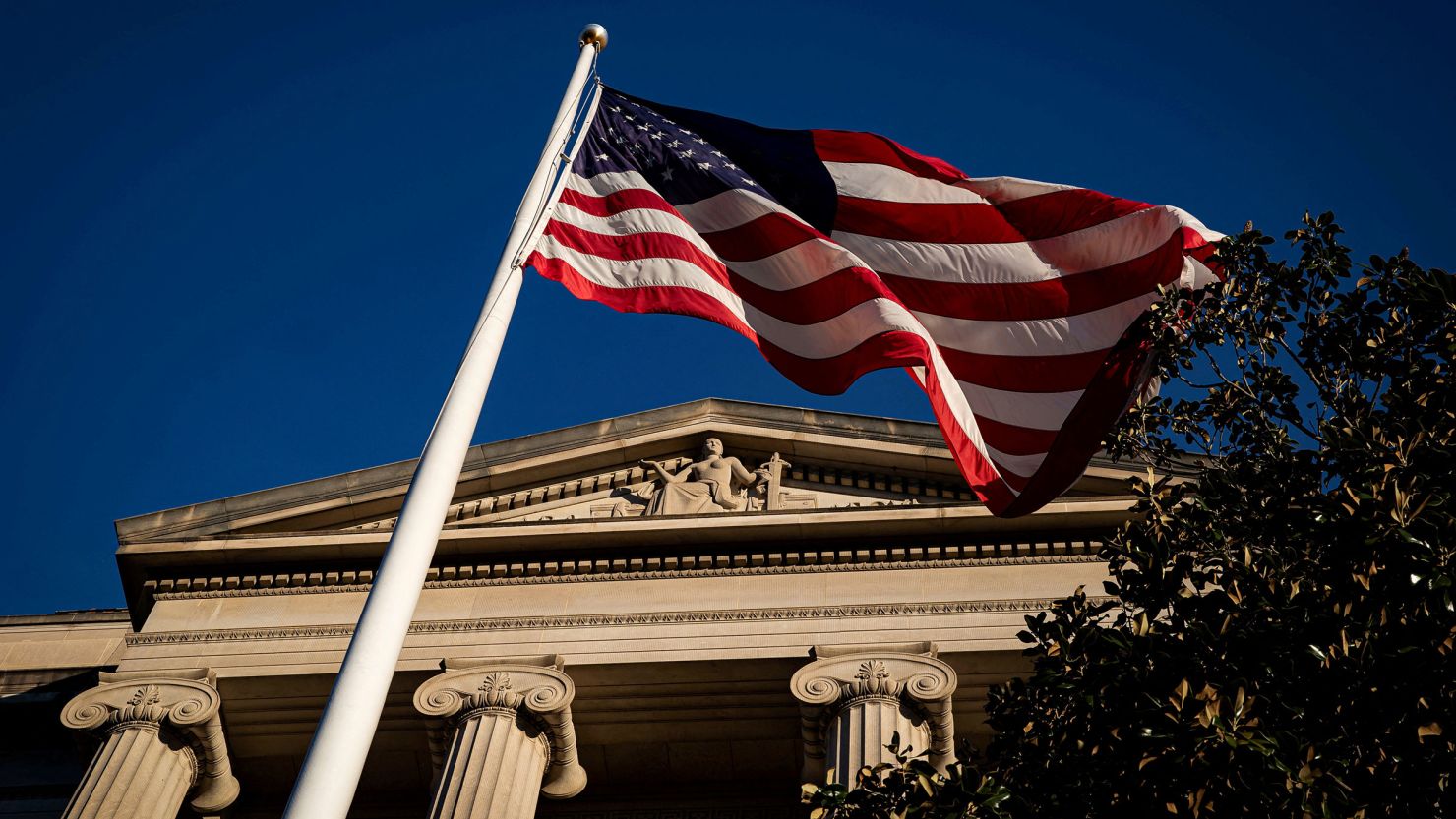 An American flag waves outside the US Department of Justice Building in Washington, DC.