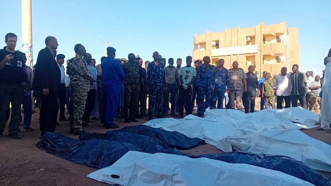 People gather next to covered bodies, following shelling by the Rapid Support Forces, in Omdurman, Sudan, 0n December 10, 2024.